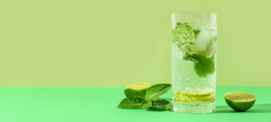 Yeşil arka planda naneli ve limonlu taze mojito.