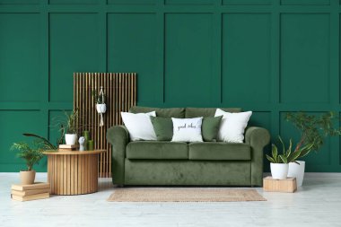 Kanepe, yuvarlak masa ve oturma odasının içindeki farklı bitkiler.