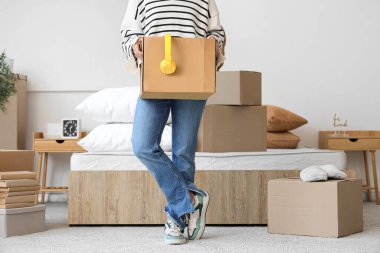 Taşındığı gün yatak odasında karton kutulu ve kulaklıklı bir kadın.