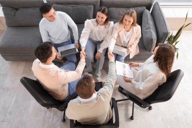 İş arkadaşları ofiste el sıkışıyor.