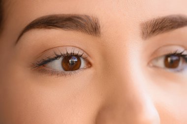 Kahverengi gözlü genç kadının yüzü, yakın çekim.