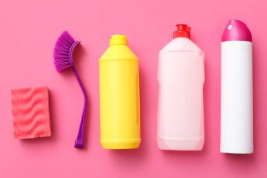 Pembe arka planda temizlik malzemeleri seti, üst görünüm