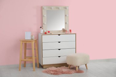Aynalı, çekmeceli ve kozmetik ürünleri satan şık bir makyaj odası.