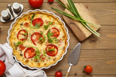 Ahşap zemin üzerinde roka yapraklı, biberli ve yeşil soğanlı lezzetli domates tartı.