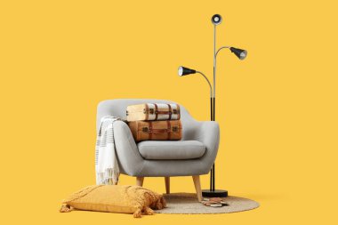 Klasik bavullu şık gri koltuk ve sarı arka planda standart lamba.