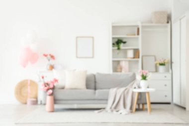 Anneler Günü 'nde kanepe, masa ve çiçeklerle süslenmiş aydınlık oturma odasının bulanık görüntüsü