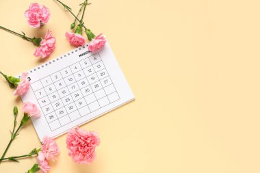 Mart ayının kağıt takvimine sahip kompozisyon ve renk arkaplan üzerinde güzel karanfil çiçekleri