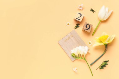 29 Mart tarihli ahşap küp takvimi ve renk arkaplan üzerinde güzel çiçekler