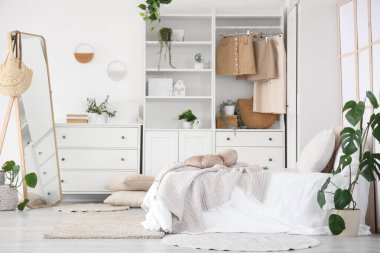 Yatağı, aynası ve dolabı olan bir gencin odası.