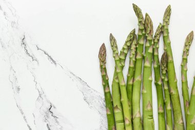 Beyaz arka planda taze yeşil kuşkonmaz, yakın plan.