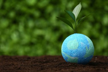 Toprakta yeşil çimlerin üzerinde filizlenen Dünya 'nın modeli. Dünya Çevre Günü