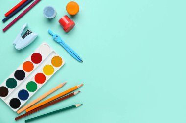 Turkuaz arka planda farklı okul kırtasiyesine sahip kompozisyon