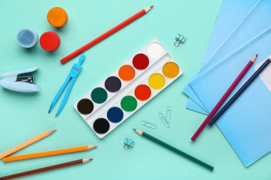 Turkuaz arka planda farklı okul kırtasiyesine sahip kompozisyon