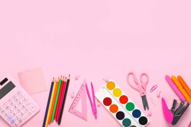 Pembe arka planda okul kırtasiyesiyle kompozisyon