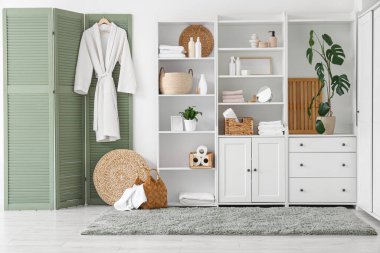 Katlanmış ekran ve dolabı olan banyonun içi.