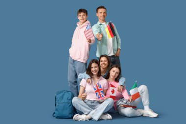 Mavi arka planda farklı bayrakları olan bir grup öğrenci