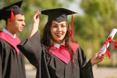 Açık havada diploması olan Asyalı bir bayan öğrenci.