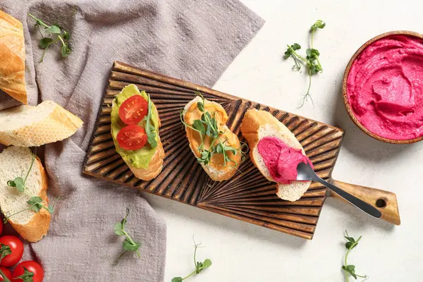 Lezzetli sandviçli kompozisyon, humus ve hafif arka planda taze lahanalar.