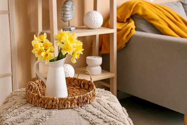 Üzerinde güzel sarı nergis buketi vazosu olan sepet tepsisi.