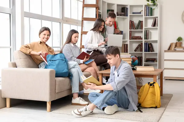 Kitapları olan bir grup öğrenci kütüphanede okuyor.