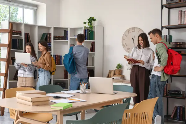 bir grup öğrenci kütüphanede okuyor.