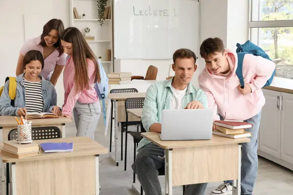 Erkek öğrenciler üniversitede dizüstü bilgisayarla çalışıyorlar