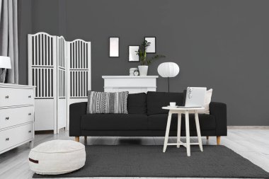 Gri kanepeli, masalı ve katlanır perdeli oturma odasının içi.