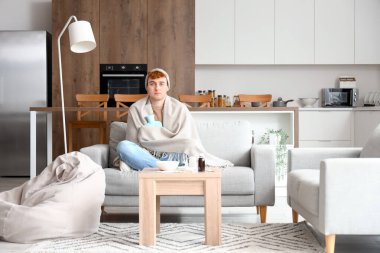 Evinde sıcak su şişesi olan genç bir adam.