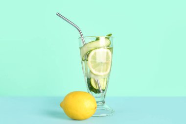 Mavi arka planda bir bardak salatalıklı limonata ve nane şekeri.