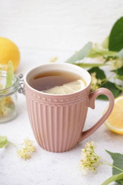 Beyaz arka planda limonlu ıhlamur çayı.