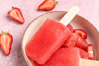 Çilekli dondurma kasesi ve pembe grunge arka planda taze böğürtlen.