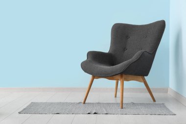 Mavi duvarın yanındaki gri koltuk