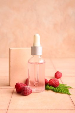 Pembe fayans masasında bir şişe kozmetik ahududu yağı.