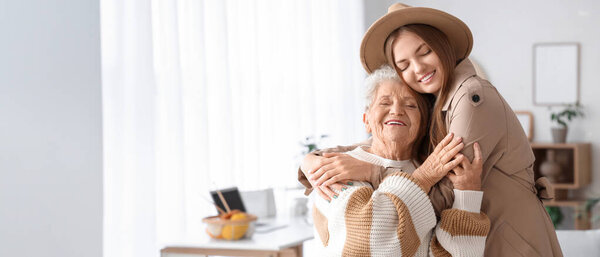 Счастливая старшая женщина и ее внучка обнимаются дома