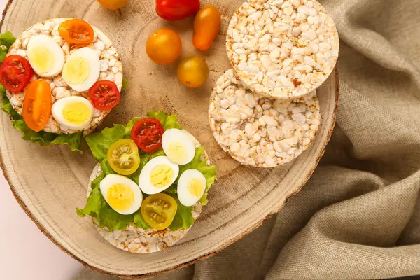Bıldırcın yumurtalı pirinç krakerleri, domatesler ve hafif arka planda marul.
