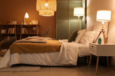 Yatak odasının içinde ekose kumaşlar ve geceleri parlayan lambalar.