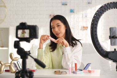 Evde ruj sürme videosu olan Asyalı kadın güzellik blogcusu