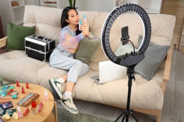 Dudak parlatıcısı olan Asyalı kadın güzellik blogcusu evde video kaydediyor