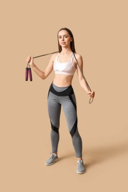 Bej arka planda ip atlayan genç bayan antrenör.