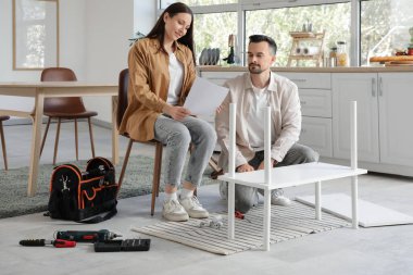 Mutfakta rafları elle monte eden mutlu çift.