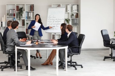 Çizelgeye yakın bayan avukat ve ofiste çalışan meslektaşlar.