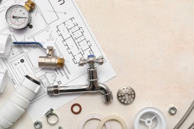 Beyaz grunge arka planında ev planı olan tesisatçı eşyaları.