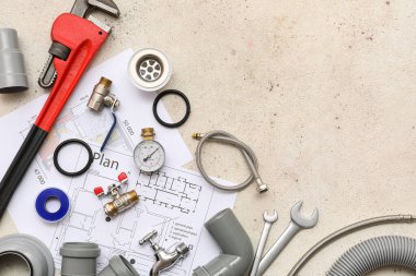 Beyaz grunge arka planında ev planı olan tesisatçı eşyaları.