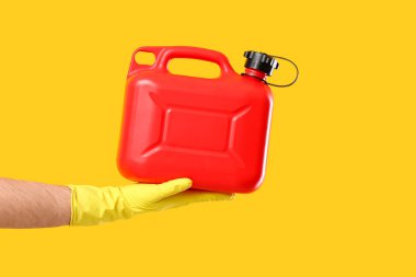 Sarı arka planda erkek el kutusunu tutuyor.