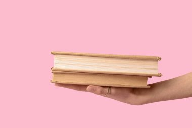 Pembe arka planda kitapları olan bir kadın.