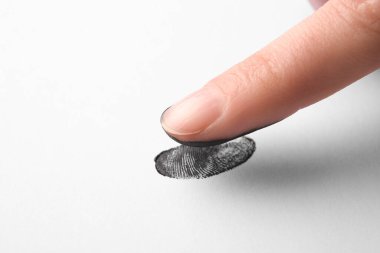 Parmak izi almak için beyaz kağıt üzerinde yuvarlanan kişi