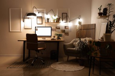 Ofis içi işyeri, koltuk ve geceleri parlayan ışıklar.