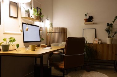 Geceleri işyeri, bitkiler ve parlayan ışıklar olan bir ofis.