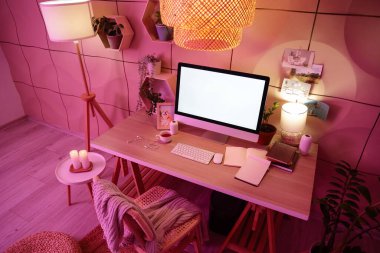 Çalışma yeri, raflar ve parlayan lambalar olan karanlık ofisin içinde.