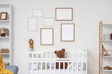 Raf üniteli çocuk odasının içi boş çerçeveler ve bebek karyolasında oyuncaklar.